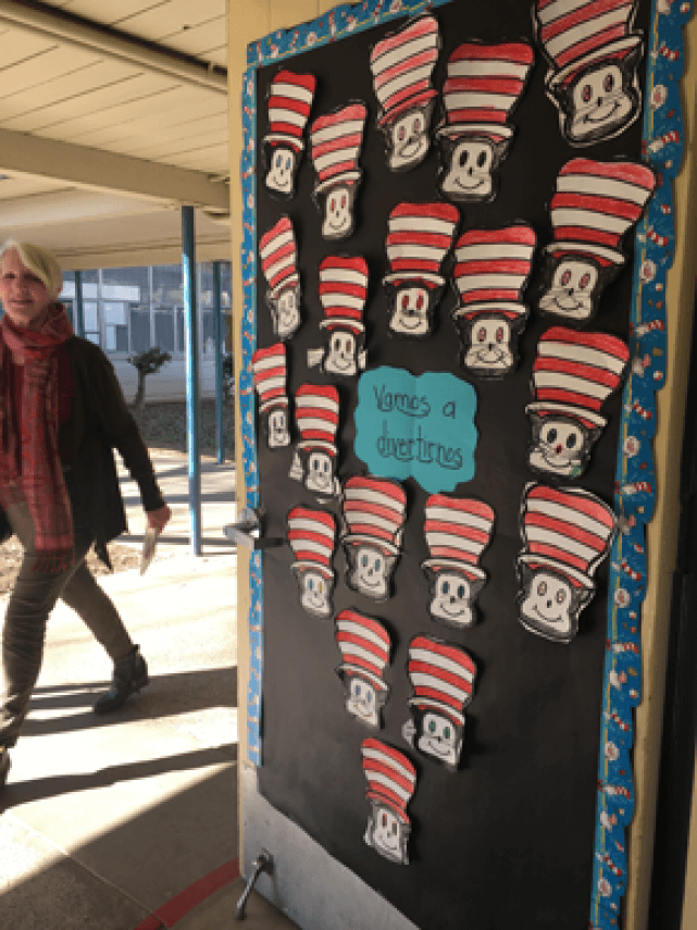 The inside of a classroom door that is propped open, decorated with cut-outs of the Cat in the Hat.